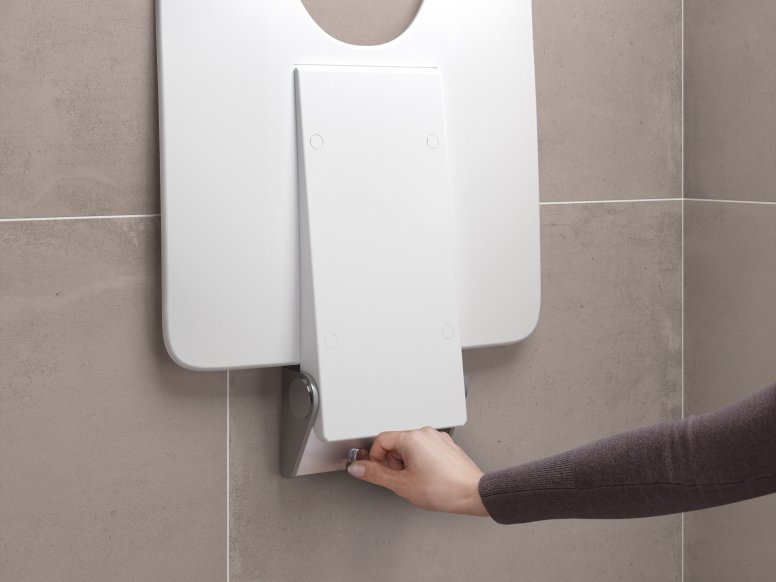 Beige tiled wall with a removable white shower seat that is mounted by one hand