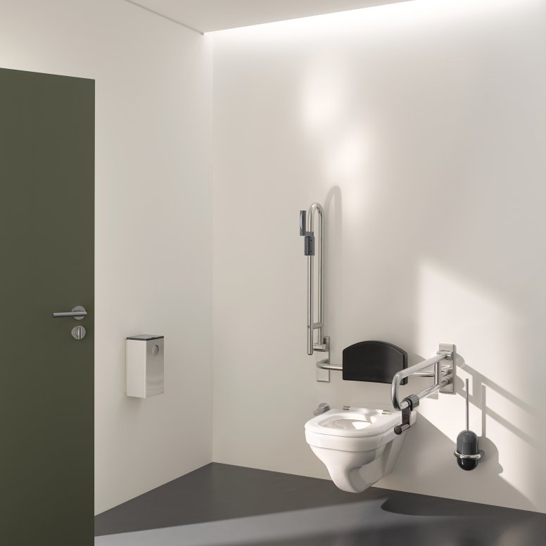 Barrier-free WC in public areas equipped with folding support handles, backrest and toilet brush